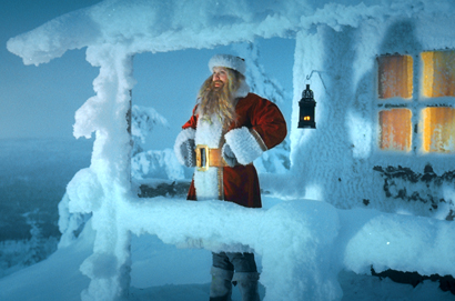 Der Weihnachtsmann steht auf einem verschneiten Balkon