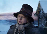 Der kleine Junge Niklas steht in einer verschneiten Landschaft vor einem Haus