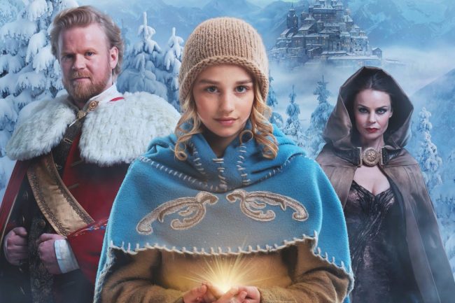 Mädchen im blauen Umhang, das leuchtende Magie in den Händen hält. Neben ihr stehen ein bärtiger König und eine düster wirkende Frau vor einer winterlichen Burg.