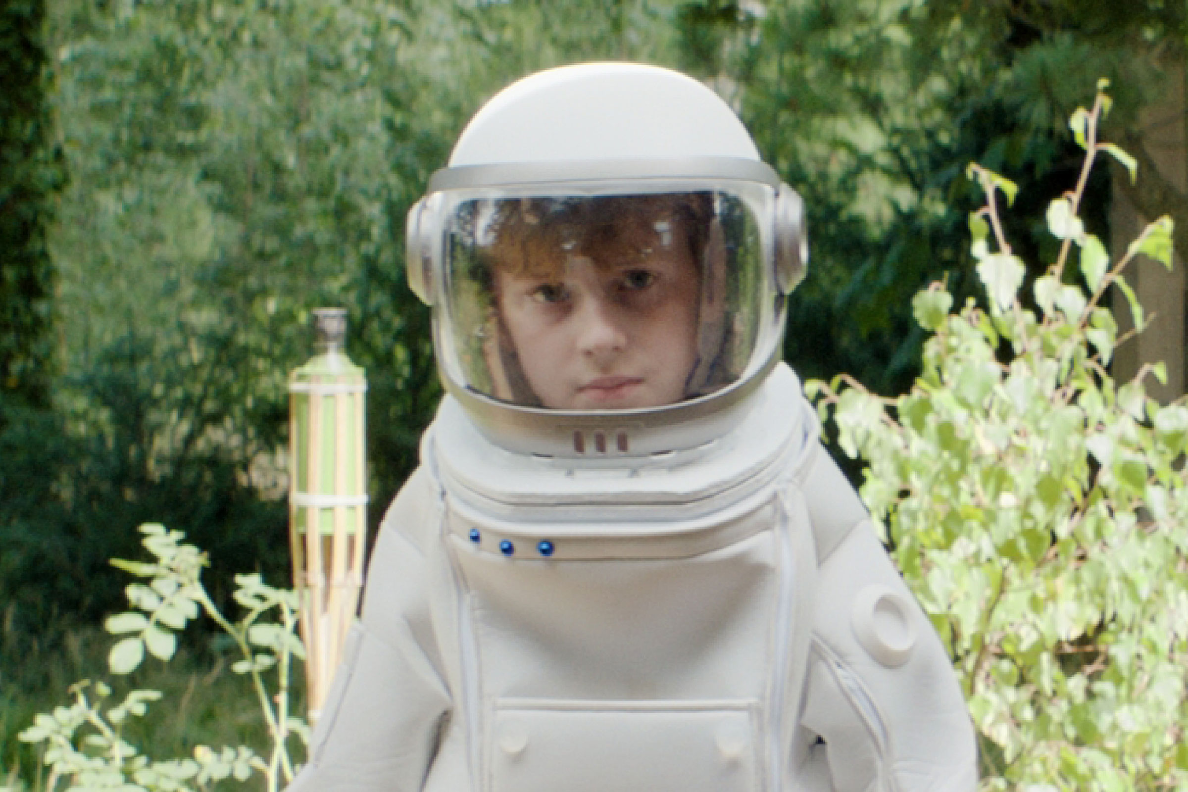 Tom steht in seinem Astronautenanzeug im Garten