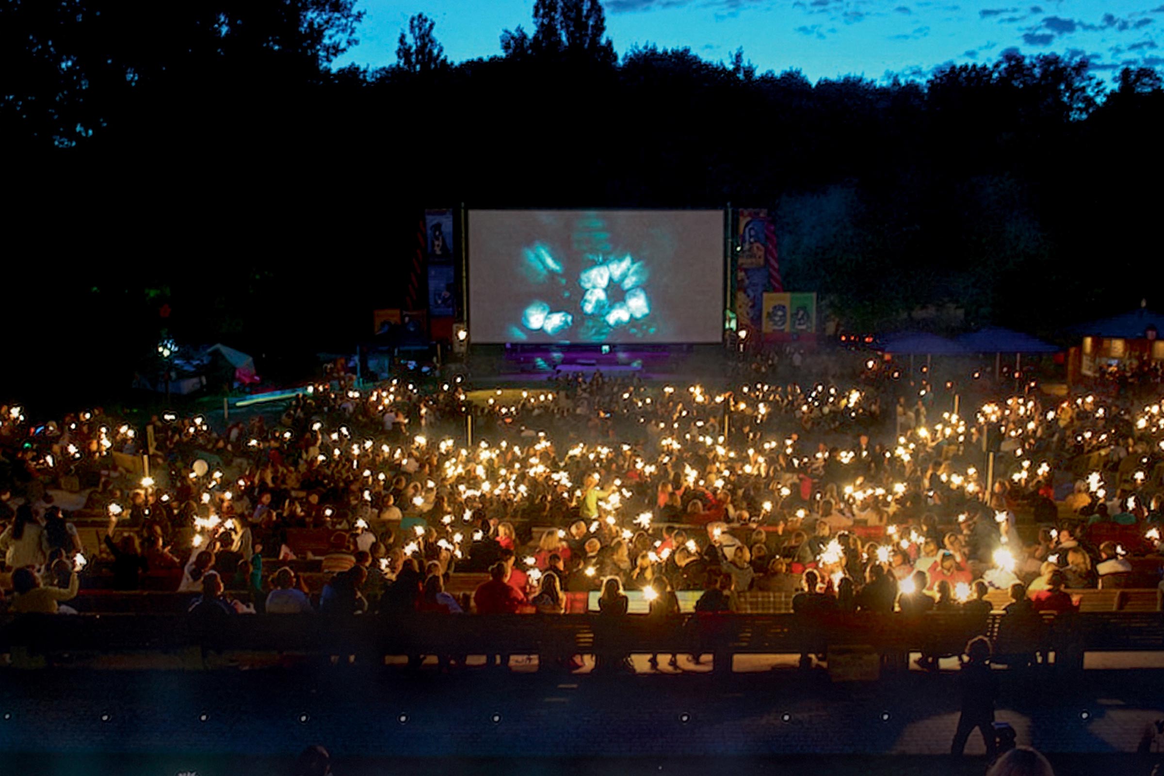 Kinderkino unterm Sternenhimmel: Abendstimmung mit einem Meer von Wunderkerzen im Publikum