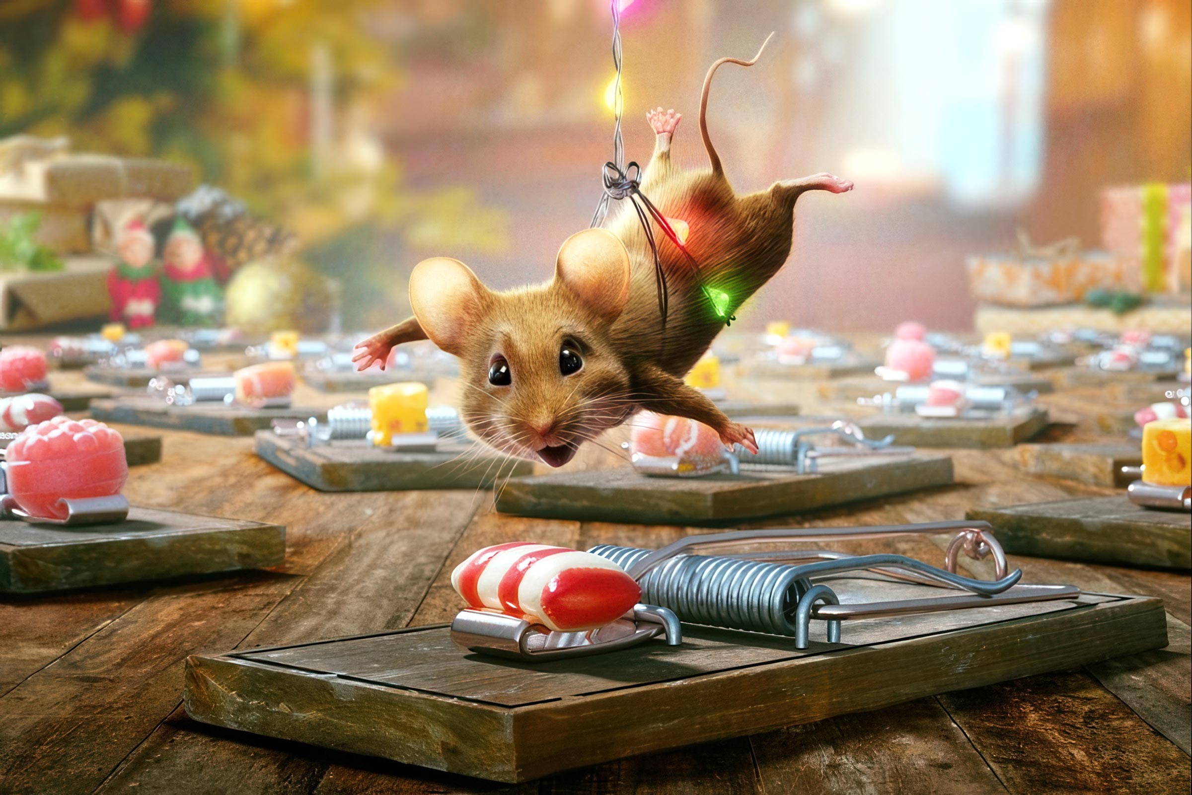 Die Maus hängt am Kabel einer Lichterkette herab und schweb über einer Mausefalle, in der ein rot-weißer Bonbon als Köder liegt