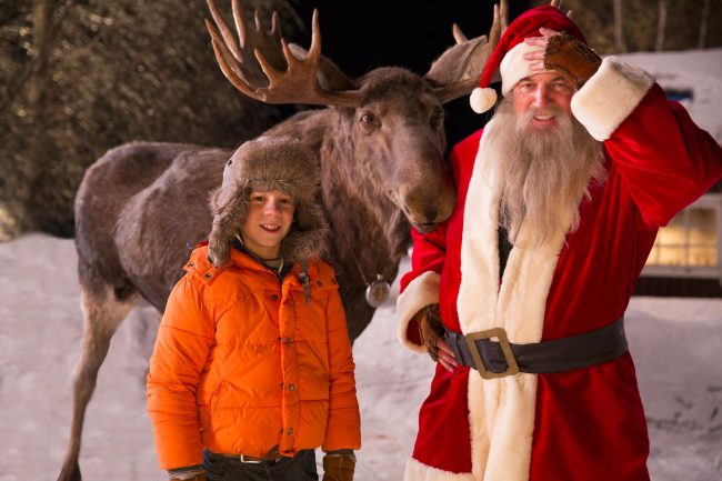 Max mit Elch und Weihnachtsmann draußen im Schnee